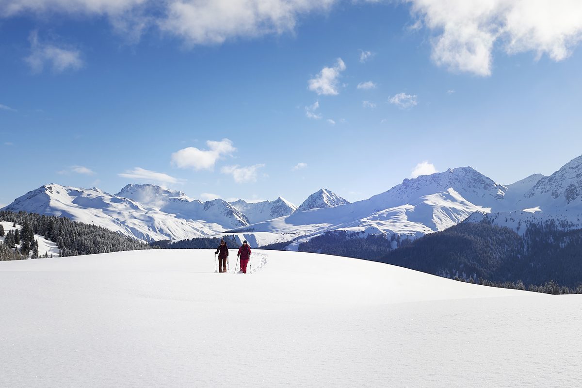 Zwei Gäste der Skischule Arosa auf einer Schneeschuhtour zwischen Maran und Prätschalp mit Blick auf die Arosa Bergwelt