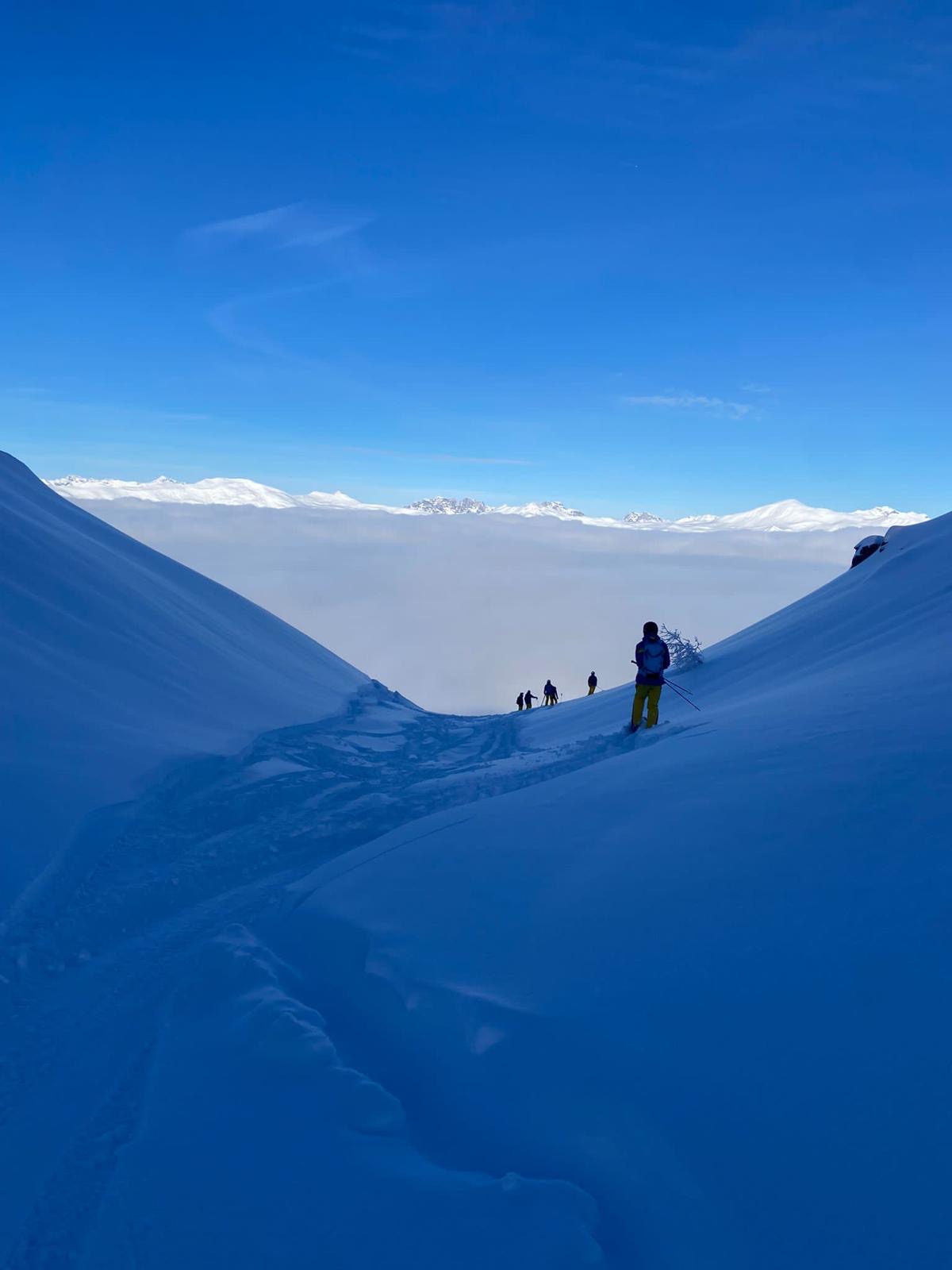 Drei Freeriderinnen und Freerider im Tiefschnee oberhalb von Arosa