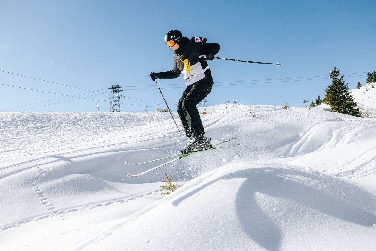 Skifahrer der Swiss Snow Academy der Skischule Arosa im Sprung über eine Geländekante