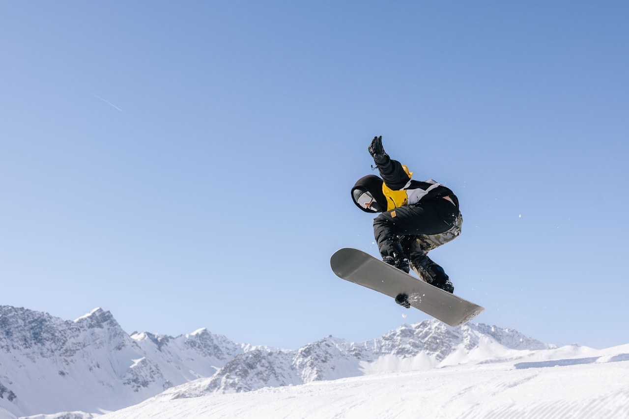 Snowboarder der Skischule Arosa in der Luft über dem Snowpark Tschuggen