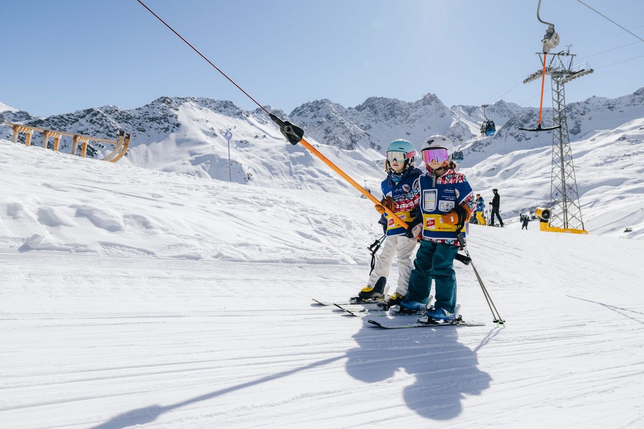 Kinder der Skischule Arosa fahren mit dem Bügellift